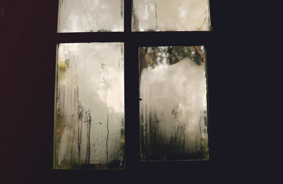 Vitre couverte de condensation dans une pièce